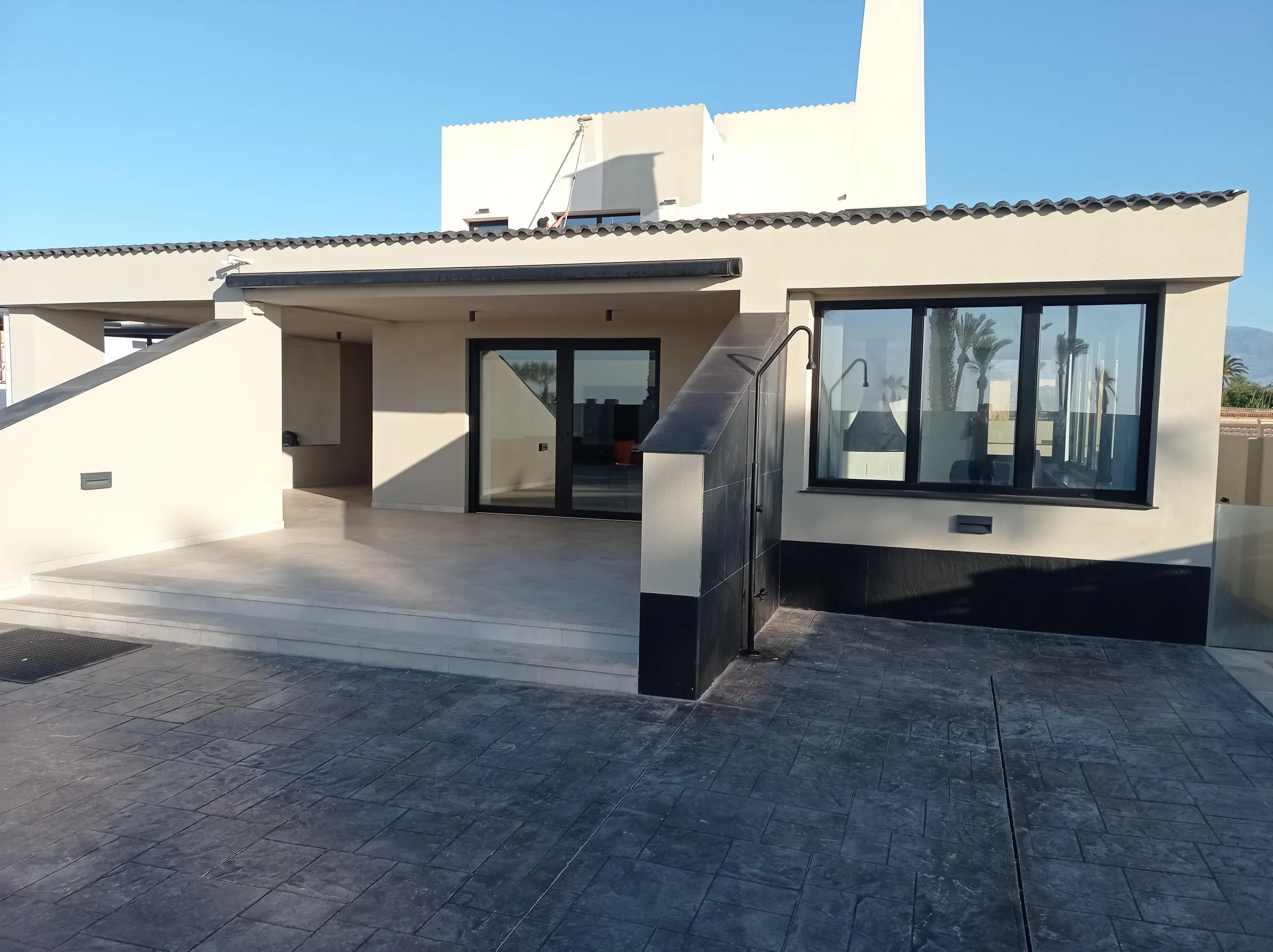 Exterior de vivienda reformada con terraza y grandes huecos